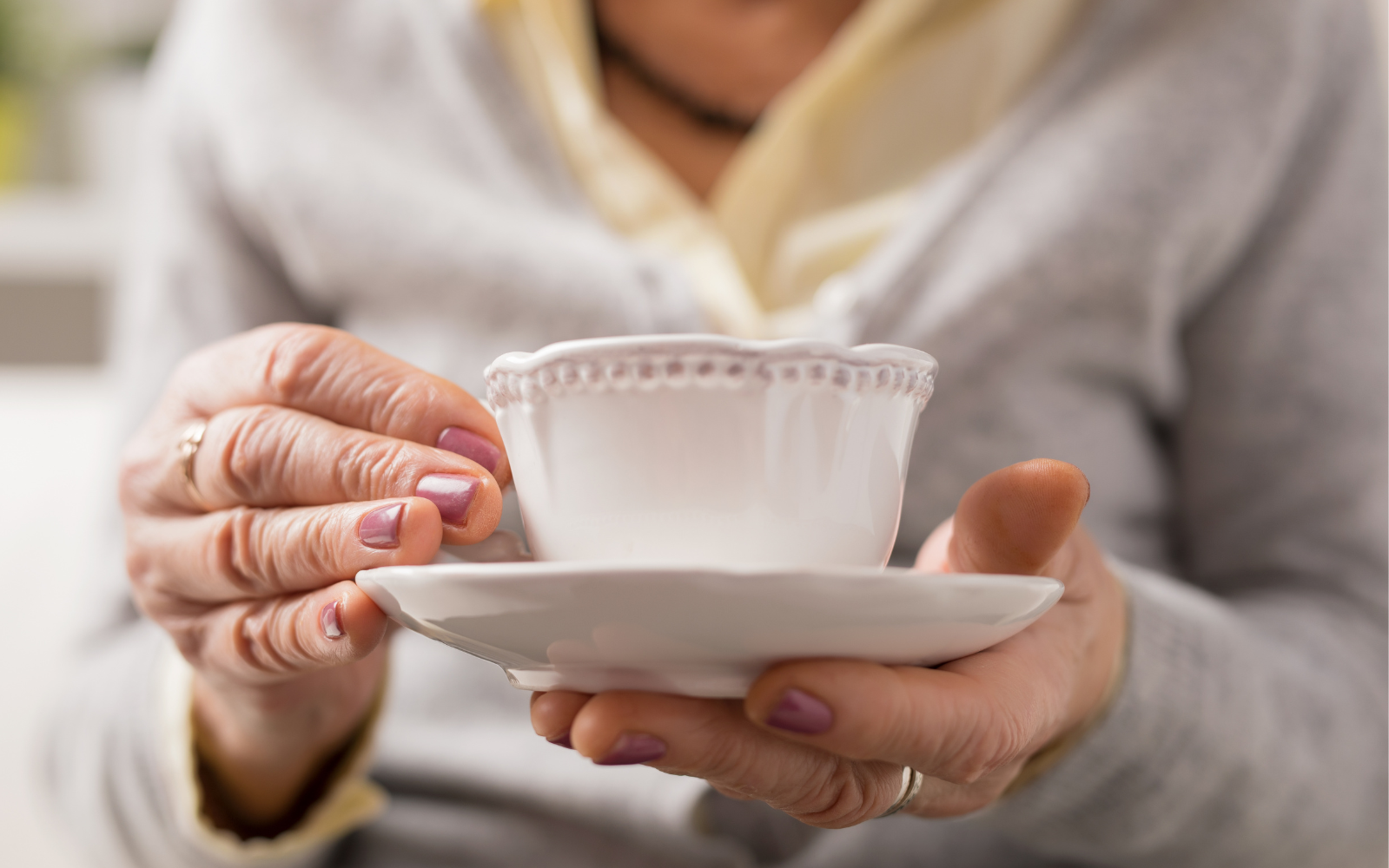 Senior holding a teacup while preparing to downsize years of memories in North County San Diego